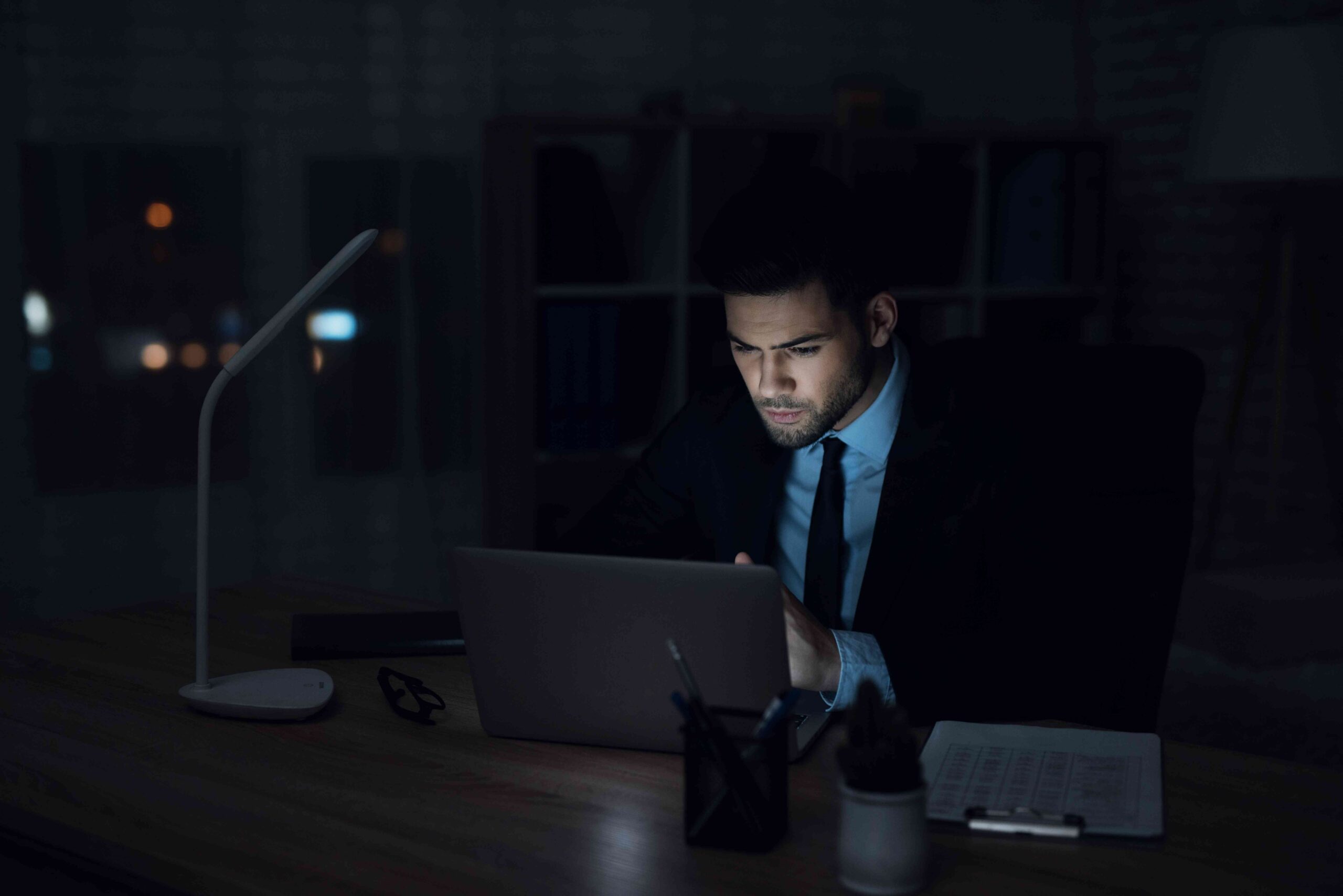 man-is-sitting-laptop-dark-office_11zon